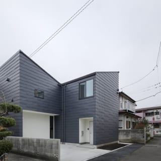 繁田諭　

【写真1】C棟 外観／外に向かって広がる片流れ屋根を持つ特徴的な外観。道路より奥まった2階部分がV字天井のLDKとなる
