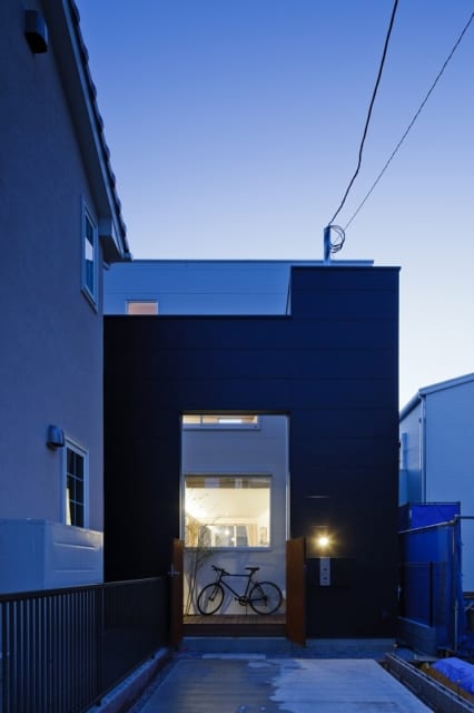 建物エントランス側の外観。玄関は１階（親世帯）と２階（子世帯）それぞれにあるが、街から見える玄関は黒い壁の一か所のみ。一世帯の一軒家のような佇まいだ。
