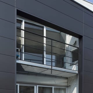 １階と２階の中間に設けた黒い壁の開口部。目線のレベルでは視線を遮りつつ、上部の空、下部の緑を見ることができる。隙間から見る景色が奥行きをつくりだす。