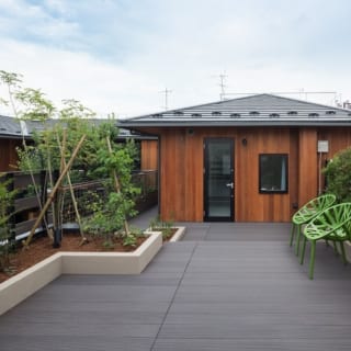 2階オーナー邸　ルーフバルコニー／1階賃貸住戸の屋上を活用した広いルーフバルコニー。写真正面はオーナー邸の子ども部屋。ルーフバルコニーへは子ども部屋前の通路から出入りする。植栽スペースを彩るのはオリーブやレモン。自動散水で手入れもラク