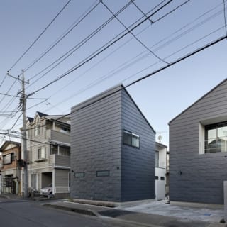 繁田諭　

【写真9】A棟 外観／ひとつの敷地に2戸のL字型の家をうまく収めている。お互いの視線が気にならないよう家の配置をずらし、窓の位置も考えた。B、C棟と同じ黒いガルバニウム鋼板の外壁だが、それぞれの印象が異なる
