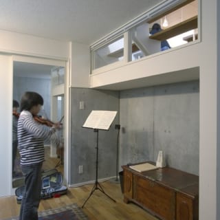 音楽室でバイオリンを練習中。鏡を置いて、フォームチェックをすることもできる。右上の窓の向こうはLDK