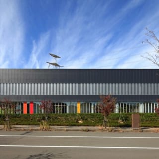 撮影：GEN INOUE

東面／住宅地から望む景色。日本、ドイツそれぞれの国旗の色とコーポレートカラーがアクセントになっている。2階窓部分の有孔折板も、壁の圧迫感を軽減している

