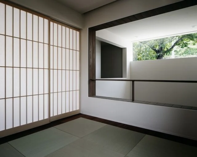 2階　和室／リビング隣接の和室は、1階の土間の吹抜けに面している。吹抜け側は断熱性のある和紙ブラインドで、すべて開けると土間のハイサイド窓を通して隣の実家の桜が見える。ブラインドとリビング側の障子を閉めれば完全な個室になり、客間として使用できる