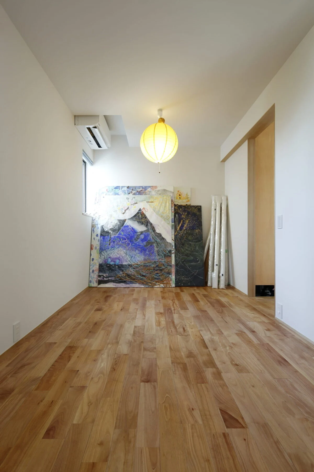 奥さまが描いた絵画を飾った１階の洋室。将来的に２つの子供部屋に区切れるように入口を二つ設置している。