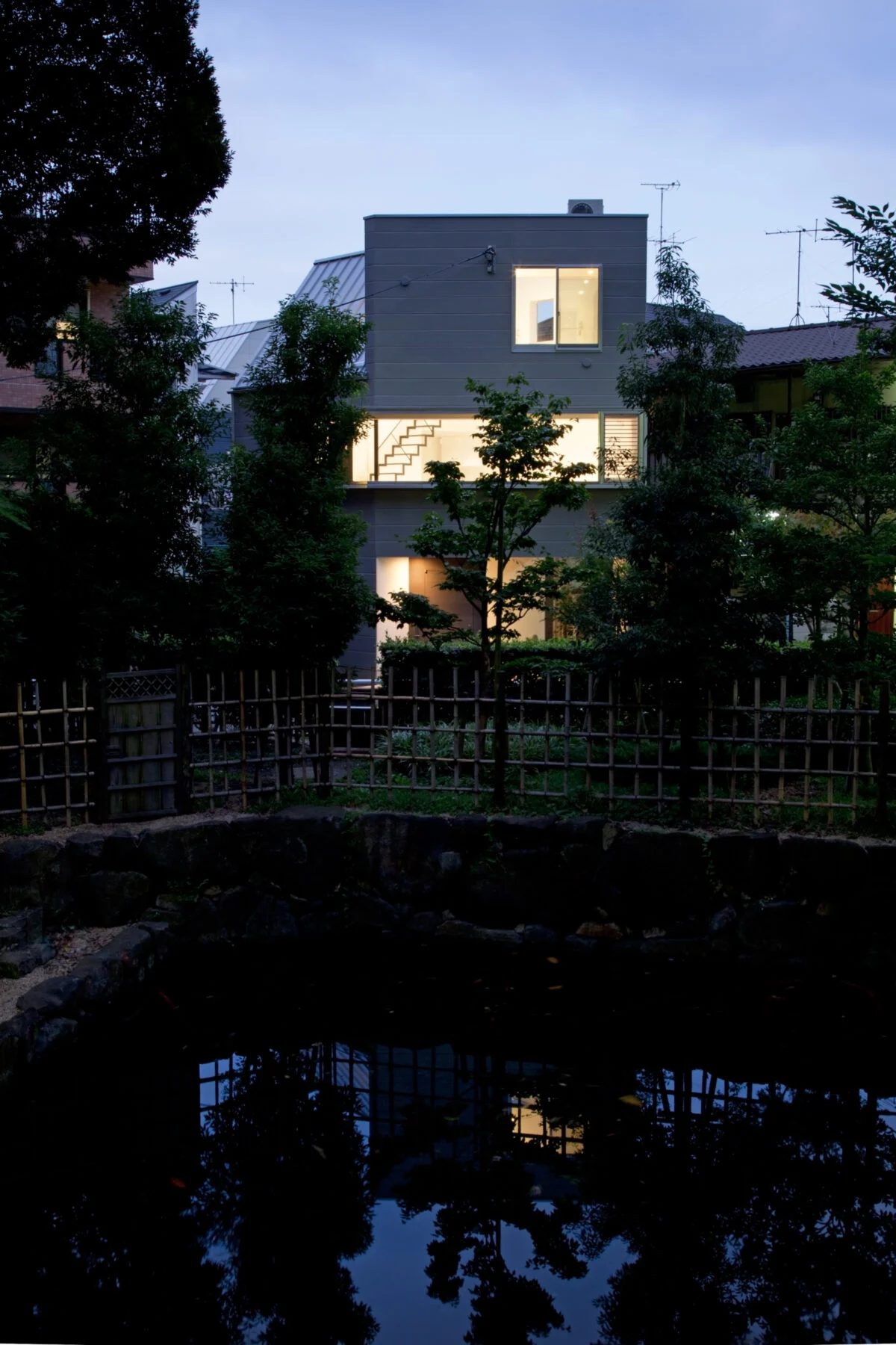 公園から見た夜景。公園には起伏があり、２階のレベルが大体、公園のレベルとなります。建物の横長の窓は、そのレベルに合わせるようにつくったものです。建物の前は丁度池となっているため、横長の窓からは公園の奥まで見通せます