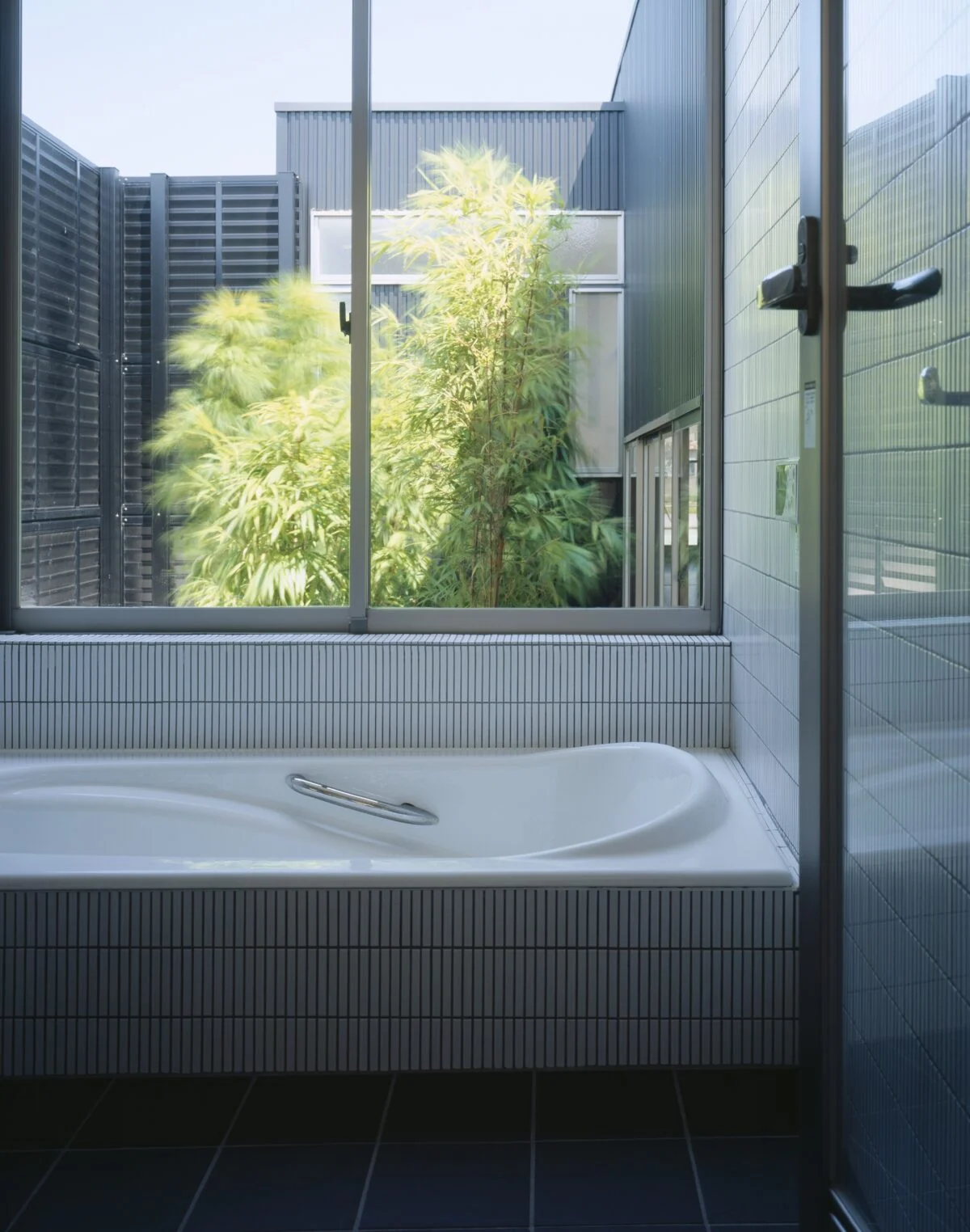 庭の植栽を望むバスルーム。周囲を囲まれているので窓を開けても外からの視界は気にならない