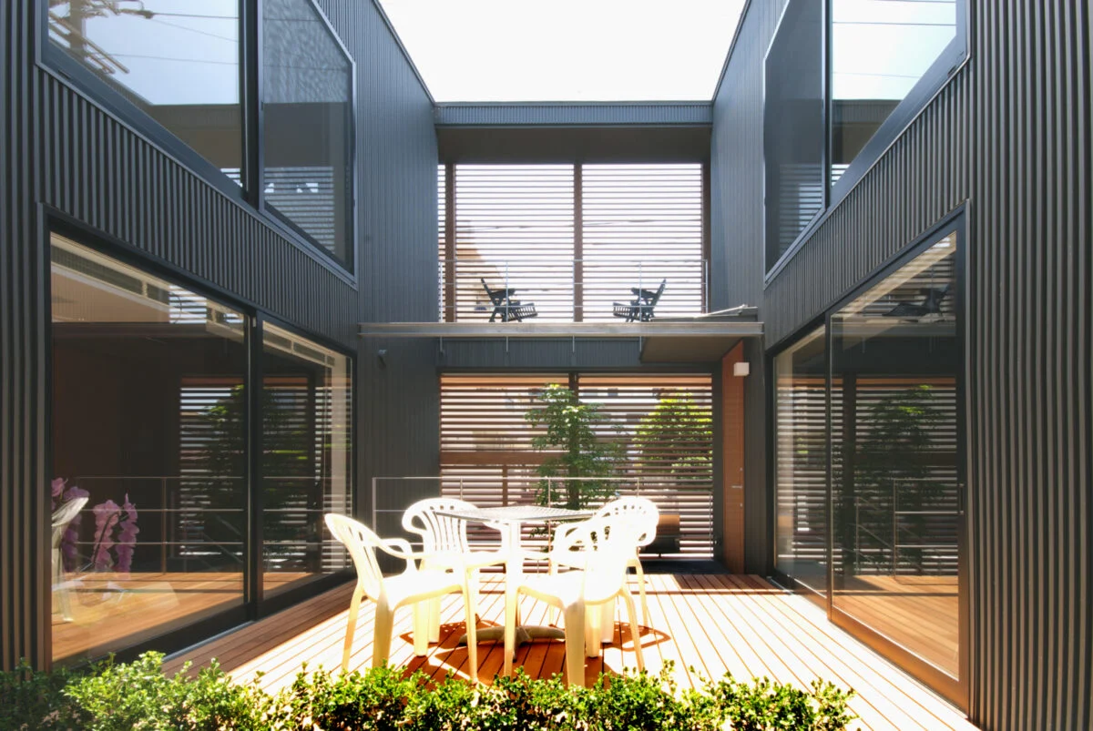 母親の住まいの和室から見た中庭。木製のルーバーが目隠しとして機能し、開放的ながらプライバシーが確保されている