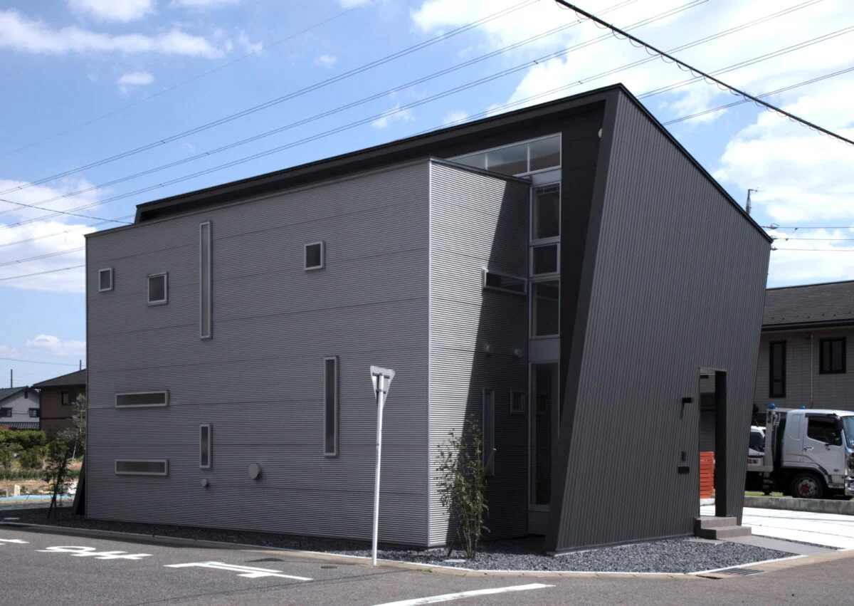 北側より見ると黒い大屋根とシルバーのボックスを組み合わせていることがよくわかる。たくさんの窓が光と風を取り込む