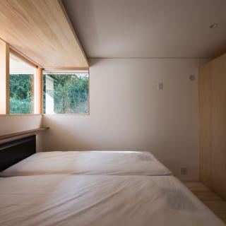 南角に位置する寝室。天井より仕切壁を低くすることで、先にも部屋があることを示唆して、空間に広がり感を持たせている