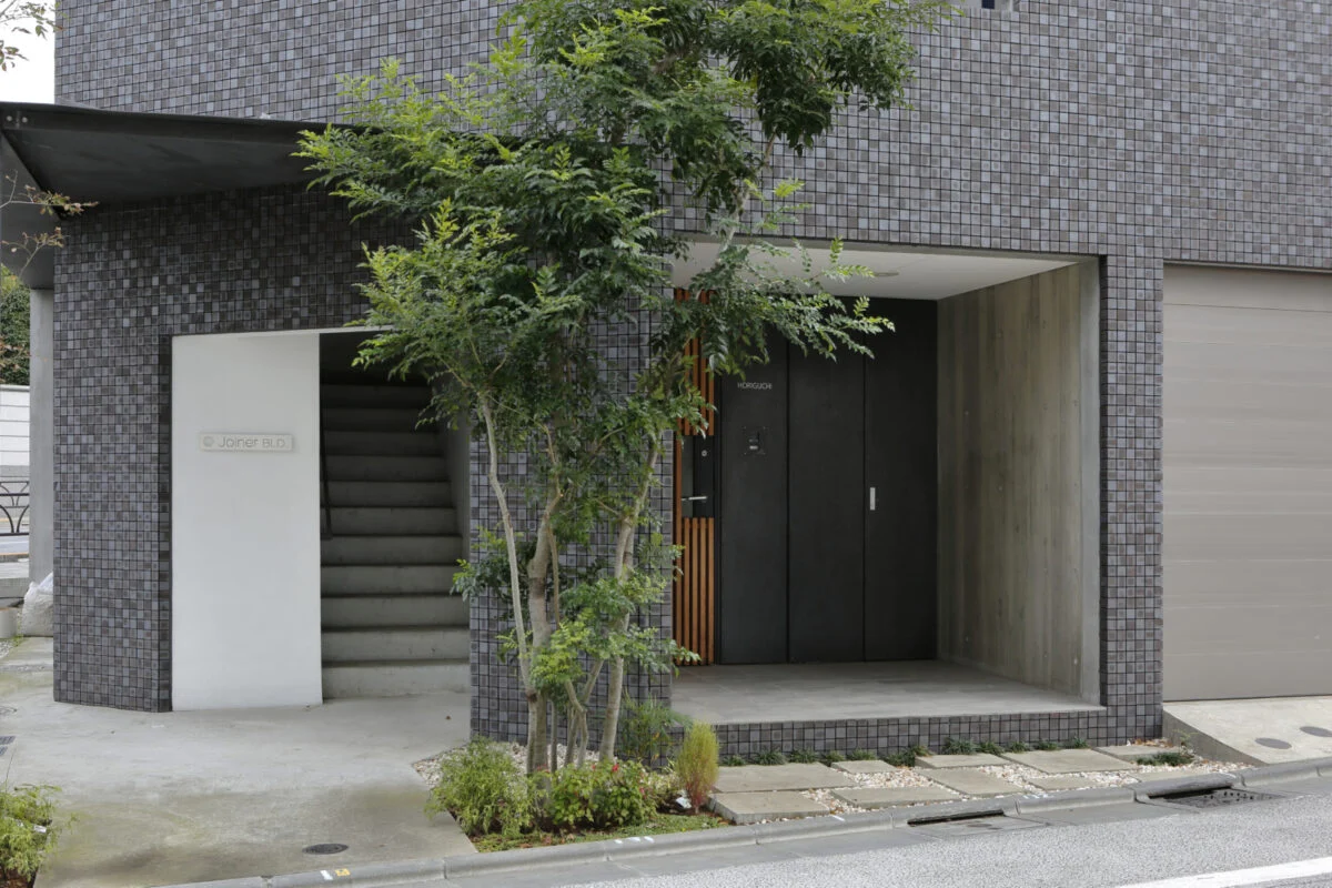建物の駅側にある、１階エントランス。中央には、３階４階へのエレベーター用勝手口がある
