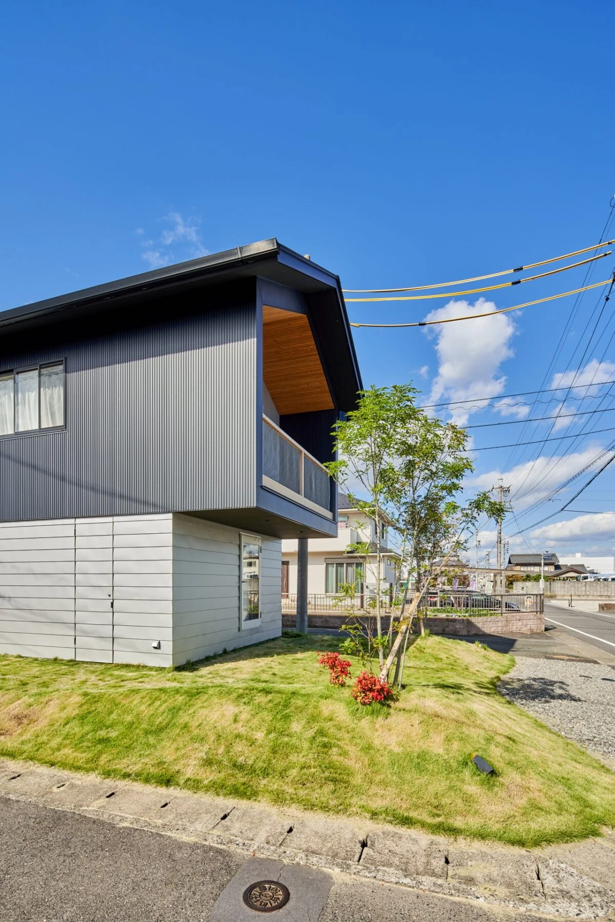 2階部分をオーバーハングした個性的な外観スタイル。下（1階部分）の箱に家のカタチの建物が乗っているイメージ