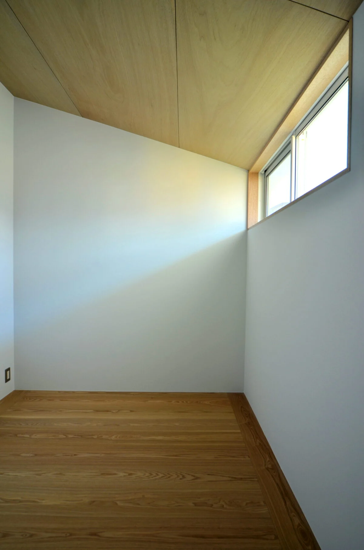 白い壁と木材のコントラストが美しい、シンプルなつくりの子ども部屋