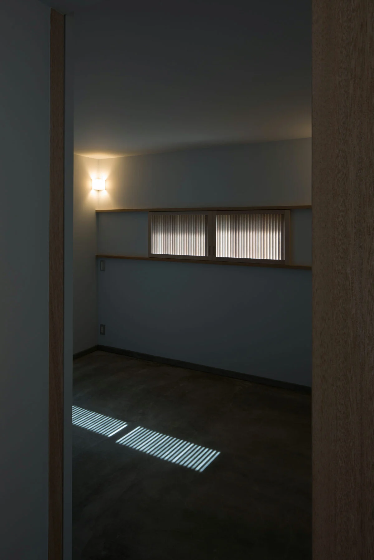 夫婦の寝室。こちらの床もモルタル敷きの土間仕様となっており、引き戸をあけると土間と一続きとなる