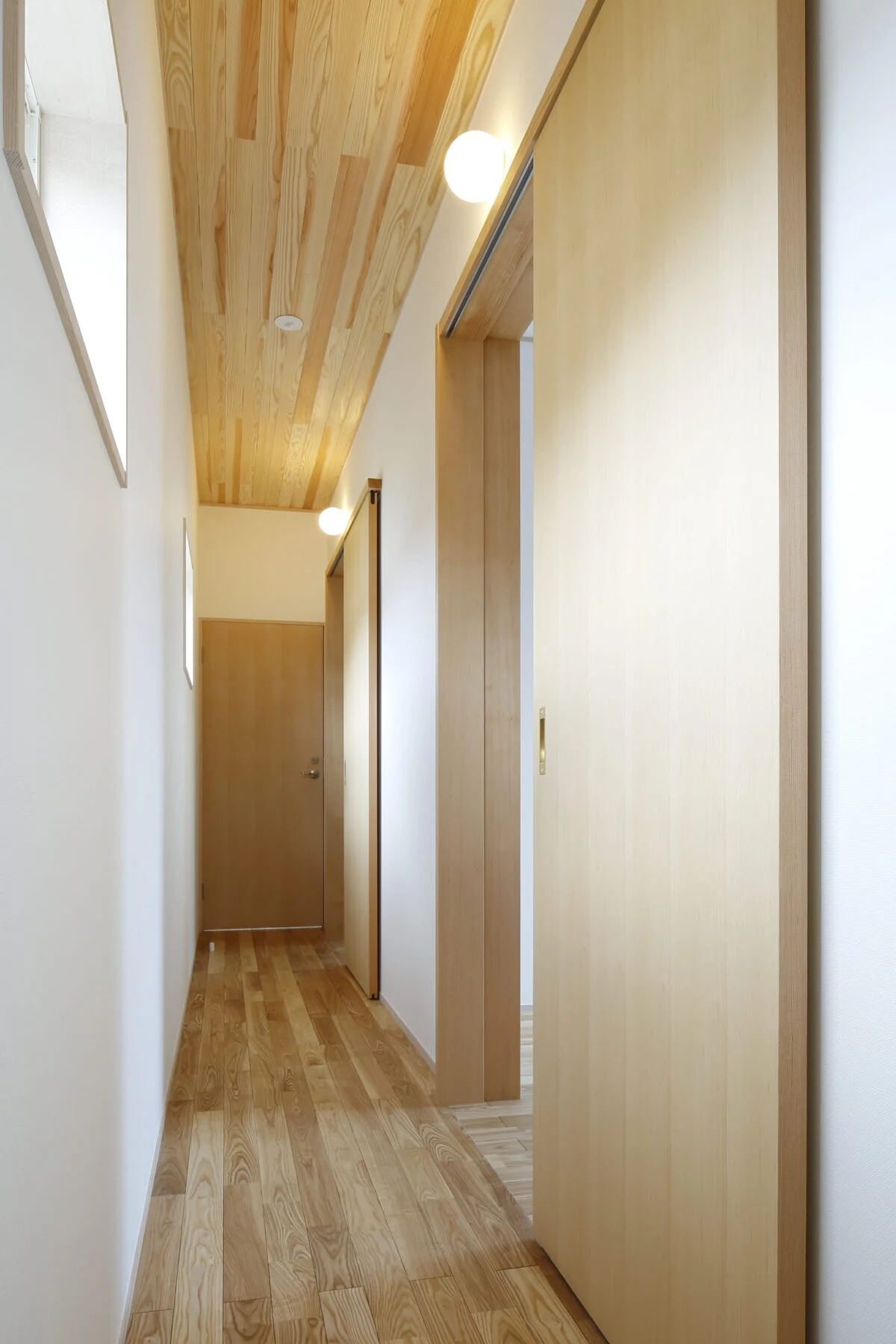 2階の廊下は、各子ども部屋の入り口にある丸照明もアクセント。まるでホテルのように、部屋が並ぶ