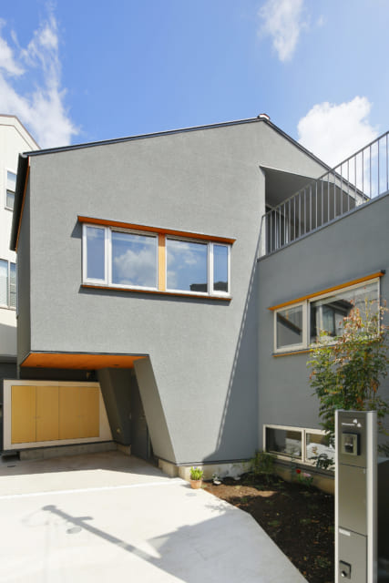 Ｓ邸の外観。駐車場の上に居住空間が張り出した変化のあるフォルムが特徴。南側は10ⅿほど視界が開けるため、こちらに向けて開口部を設けている