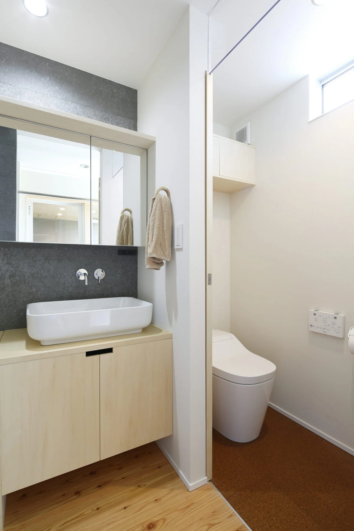 1階の洗面室とトイレは隣接し、トイレ用手洗いが不要な造り。トイレ上部から入る光が洗面室も明るく照らす