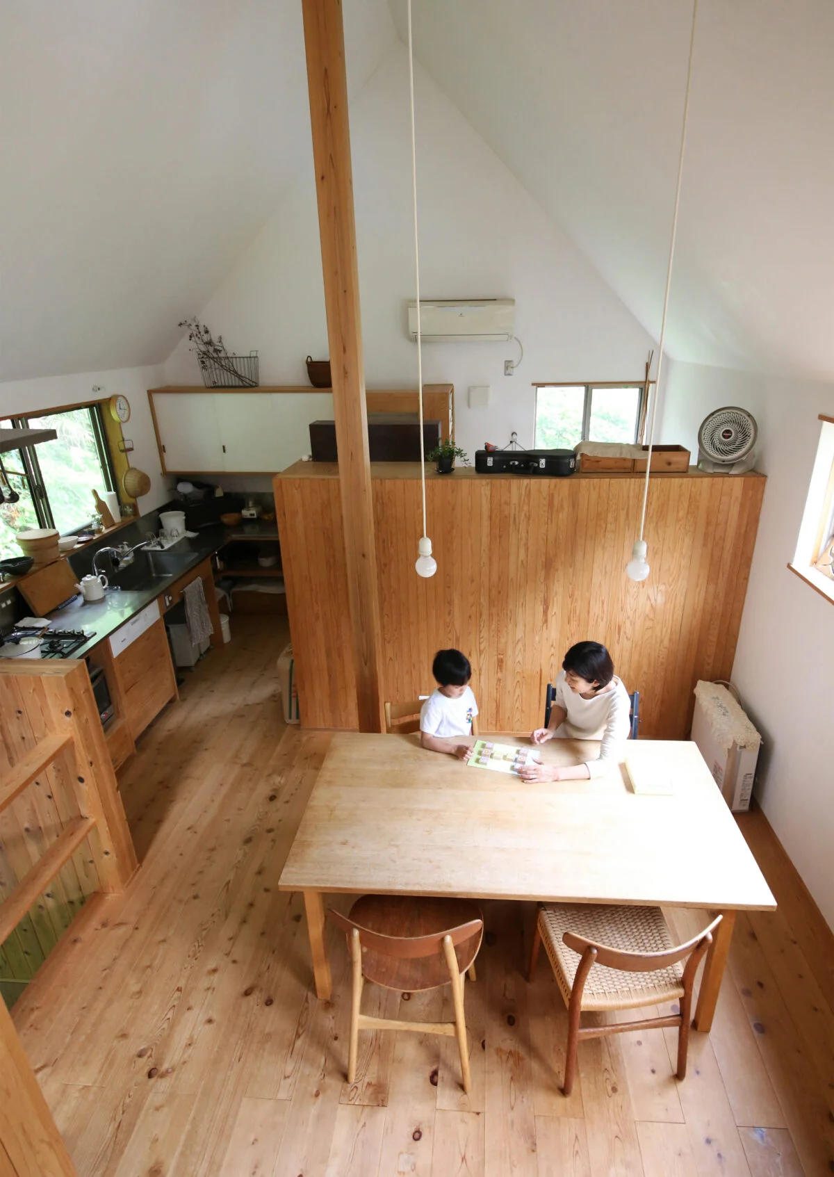 2階は高い三角天井のおおらかな大空間。壁は漆喰、床は無垢のサワラと、自然素材を贅沢に使っている