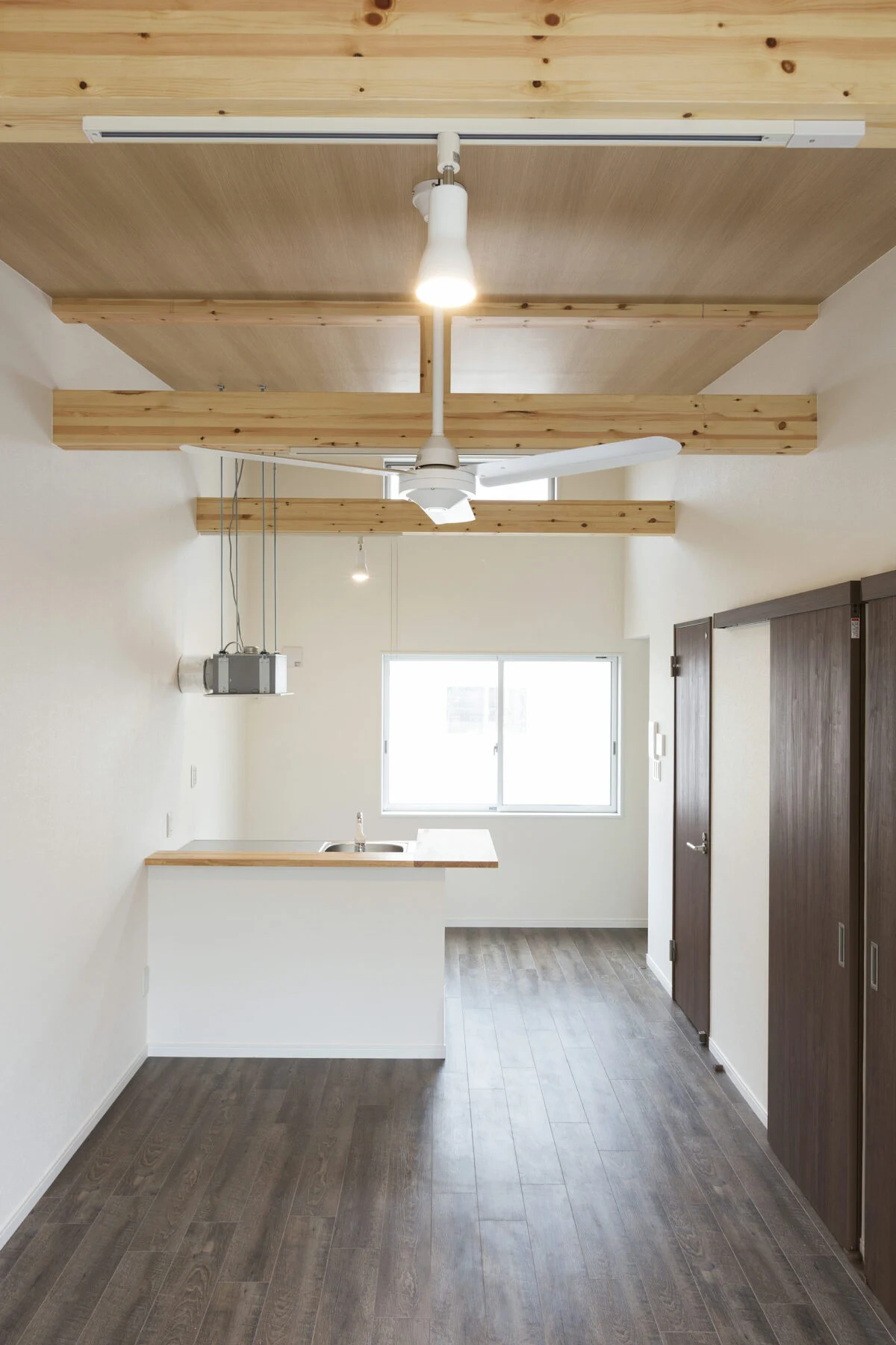 205号室。構造材を見せて天井の高さを出した屋根裏風の部屋。床の色調もシックでクールな雰囲気