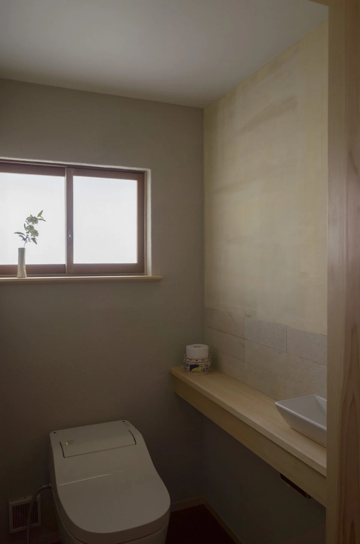 トイレは広げ、手洗いを新設。手洗い側の壁に張ったのは、少しざらついたテクスチャーが魅力の溶岩石