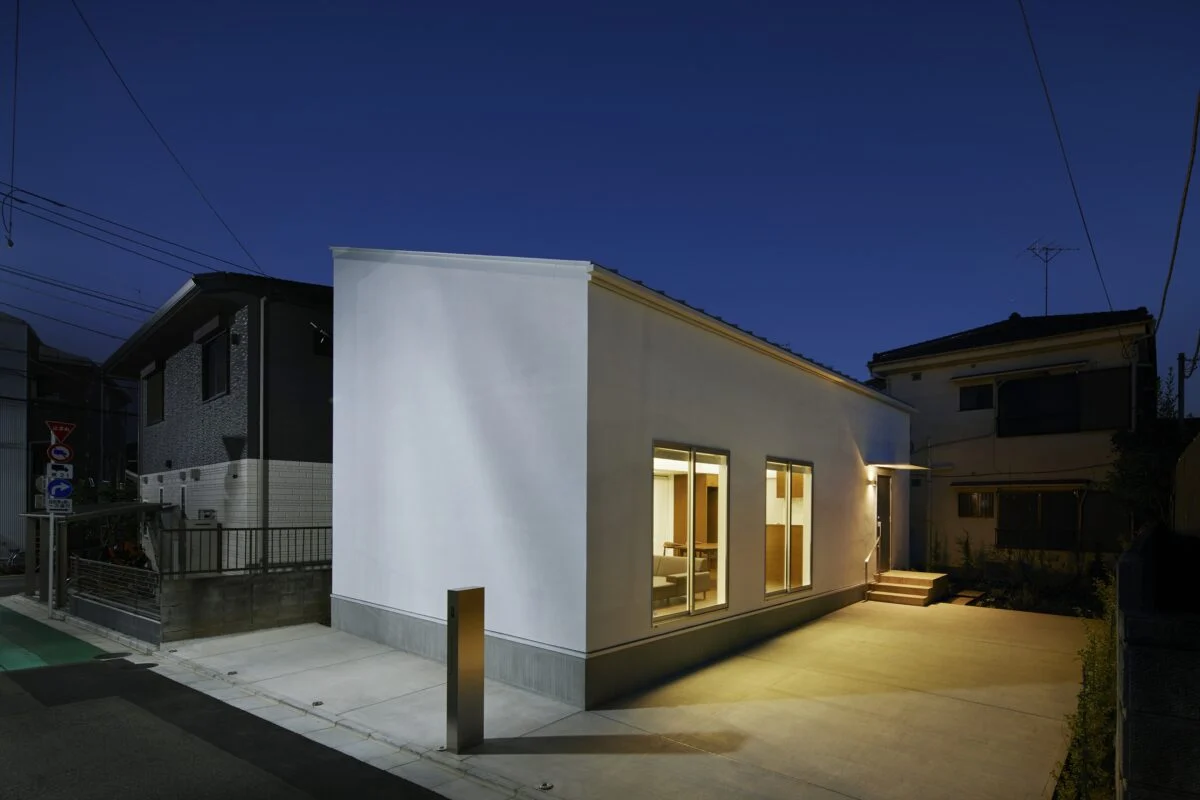 外観夕景。外構にはあえてライトを設けず、建物から漏れる光だけで敷地全体が明るくなるよう計画した。2階テラスの照明もつけると屋根から空に向かってほんわりと発光し、神秘的な佇まいになる