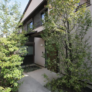 玄関へのアプローチ。建物をL字に凹ませてできた余白を前庭にすることで、旗竿地でもゆとりを感じる造りに