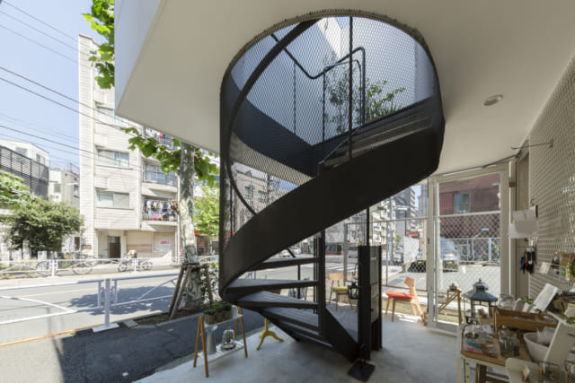 1階貸店舗の前はスペースを広く取り、店先で立ち話をしたり、雨宿りをしたりと、地域の方々がちょっと憩える空間になるように意識した。ここには2階へのぼるらせん階段もあり、2階～4階に広がる住居へのアプローチの役割も果たす