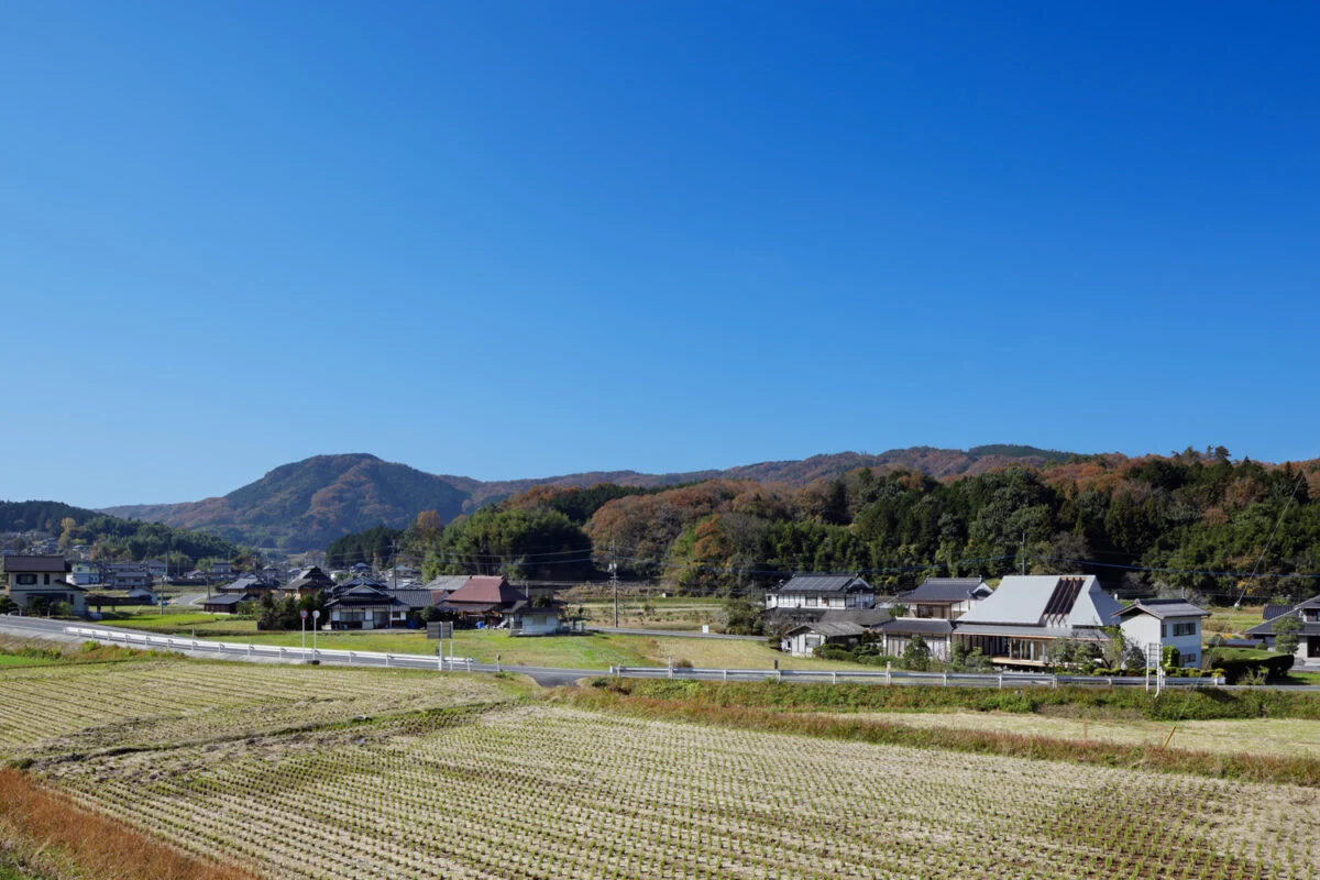 岡山県の田園風景に佇むKさん邸。遠景からは、屋根に穴があいたような独特のフォルムが存在感を発揮
