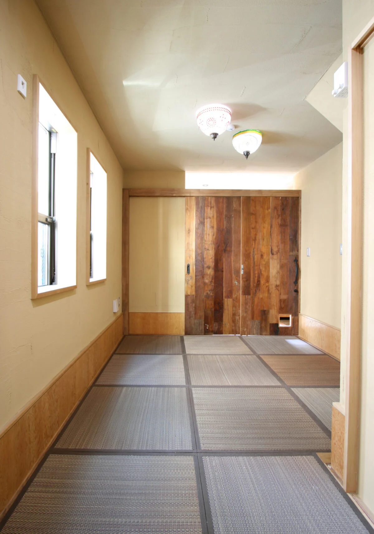 親世帯の和室はカラーリングされた畳で温かな雰囲気に。奥の引き戸を開けると、共用土間とひと続きになる