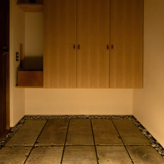 玄関には以前K様のご実家の塀に使われていた大谷石を転用した。「古いものを生かすことも大事」と堀井さん