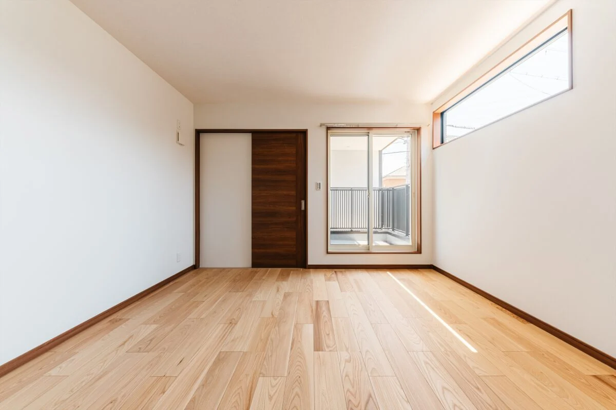2階主寝室。東のバルコニー（写真正面）は、道路側を壁で囲った。南（写真右）には人の動きは見えないハイサイドの横長窓。いずれもプライバシー確保と採光を両立させている