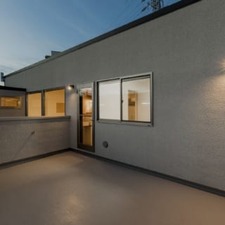 カーポート上のバルコニー。大人数でのBBQも可能な広さ。扉の脇には小さな手洗い場をつくるという工夫も