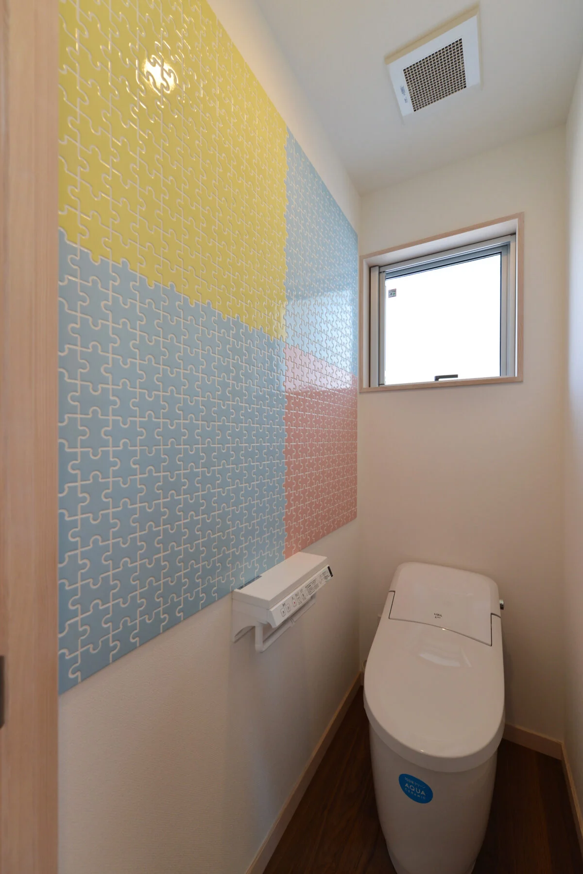 １階トイレ。お客様も使用するトイレには、カラフルなパズル柄のタイルを貼った