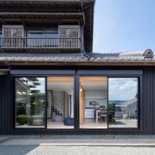 大きな窓から見えるモダンなインテリアのLDK空間と、純和風の外観とのデザインの対比がおもしろい