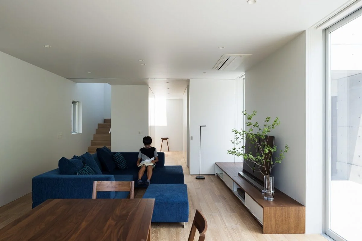 ダイニングからLDKの入口を見る。LDKの入口は3連の大きな引き戸。開け放しておくと階段や玄関（写真奥）を行き来する家族が目に入る。3連引き戸を閉めればLDKを見せることなく来客を和室（写真右奥）へ案内可能。寒い時期にLDKの暖気を逃がさない効果もある
