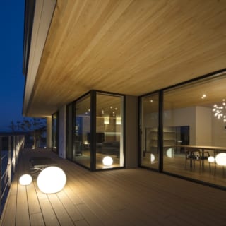 夜のウッドデッキテラス。照明デザイナーの提案で設置したボール型の照明器具はベンチとしても使える。丸い光が可愛らしく、和やかな気持ちに