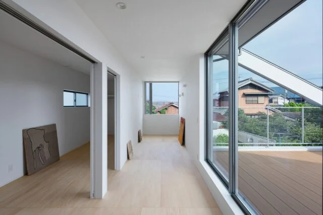 間仕切りの少ない2階。左側の子ども部屋、中央のホールは、床も同じ素材を使用しフラットに繋げることで、まるで一体空間のよう。バルコニーの窓には大窓を採用したため、採光性も抜群
