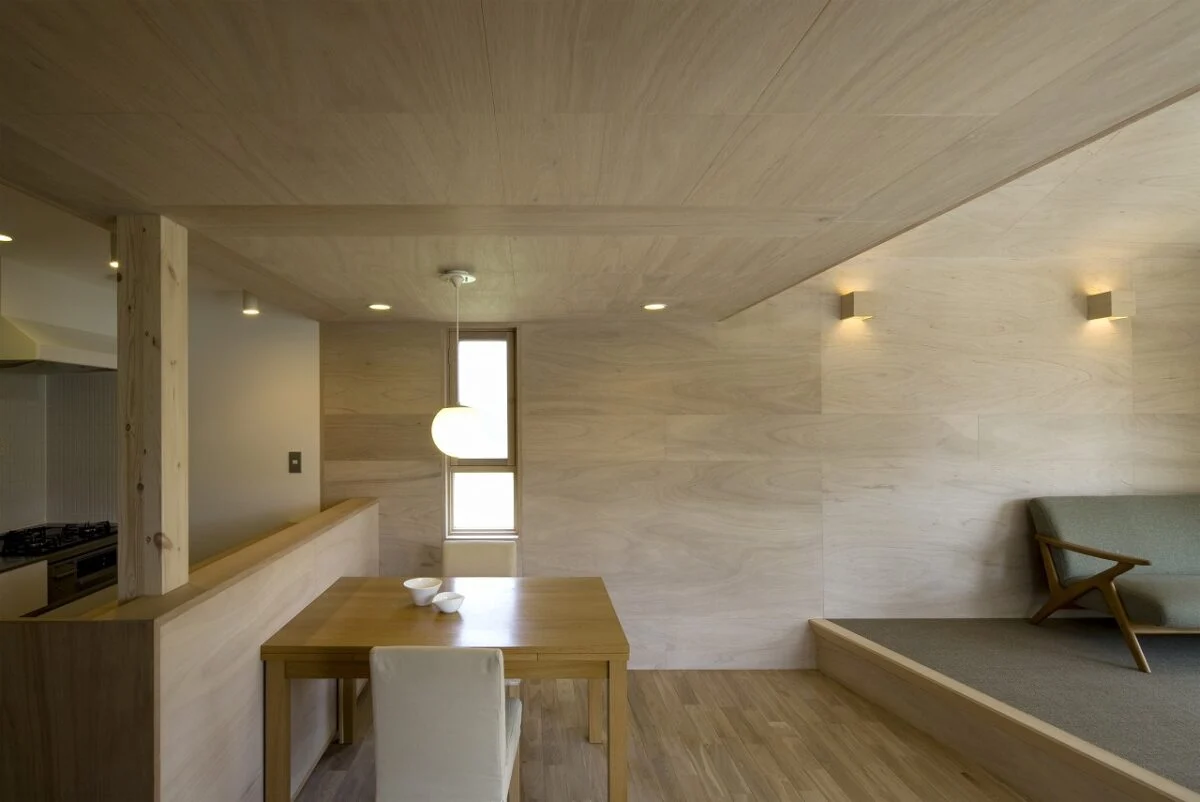 LDKへのドアの前から室内を見る。東側は建物が建つ可能性があったことから、換気のための小さな窓のみを設けた。リビングの壁に並ぶキューブのような照明もキュート。ソファは前の家から持ってきたものだが、事前に好みを把握していたおかげで空間にしっくりと馴染んでいる