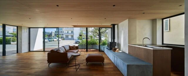 1階はかまくらスタジオのオフィスとカフェ。前面道路に面した北側（画像正面）は全面ガラス張りで、街に対してオープンな造り。ウッドデッキテラス周辺は明るく開放的だが、カフェ用のキッチンまわりは少しこもり感もあり、ワンルームでありながらさまざまな居心地を楽しめる
