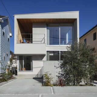 外観。敷地面積に対して建物の大きさを抑えたことで、車２台分の駐車スペースを確保、雰囲気ある植栽などゆとりある家となった。２階テラスを出発点として、のの字のように続く壁面がチャーミングな、親しみが持てる建物だ