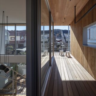 外部空間を押し込んだような、２階テラス。物干しを兼ねているため壁面に開口して風通しを確保した