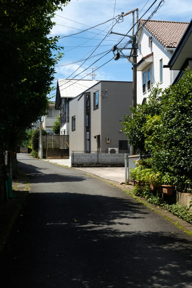 裏側も傾斜のある土地。外壁の一部を張り出させ、光や風の通り道として細長の窓を設けた。