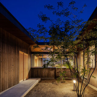 夜の「冬野の平屋」。外部の照明は壁面に付けずに、中庭に立てて配置した。家の中からも光が漏れるため、優しく照らすだけで庭は十分明るい