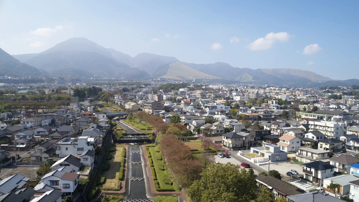 house-Nの東側から俯瞰。目の前に流れる川の両岸は砂防公園として整備され、桜並木が植樹されている。奥に見えるのは鶴見連山の山々。この素晴らしいロケーションを最大限に楽しめるようプランニング