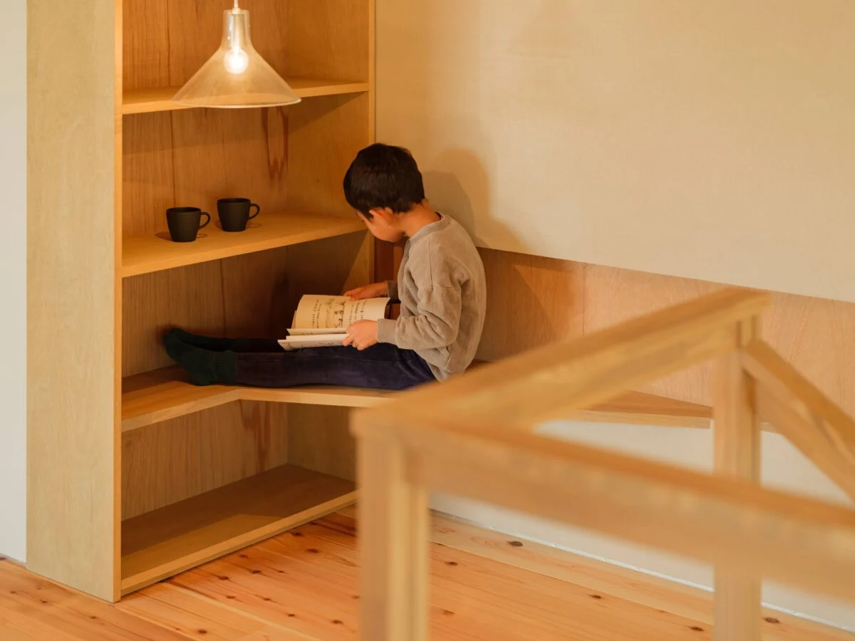 階段上にある読書コーナー。一番下は、ベンチのように腰掛けてもよし、机として利用してもよし。１つの造作に２つの機能を持たせる手腕は見事

