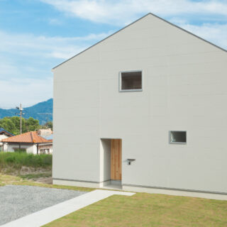家は1階と２階と外周が同じ、総2階建て。庇がなくシンプルなフォルムで、構造に無駄がないためコストが抑えられた。以前は町の集会所があった一角という「八坂の家」の敷地。アクセスがよいことに加えて、見晴らしなどの立地条件もよかったため、お施主さまは購入を決めた
