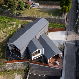 外観。建物は高台に位置する。建物の左には隣地が迫っているが、急斜面のため新しく建物は立たないだろうと判断して購入を決めた。道路を挟んだ向かいには、もう一つの購入の決め手となった食事のおいしいオーベルジュがある
