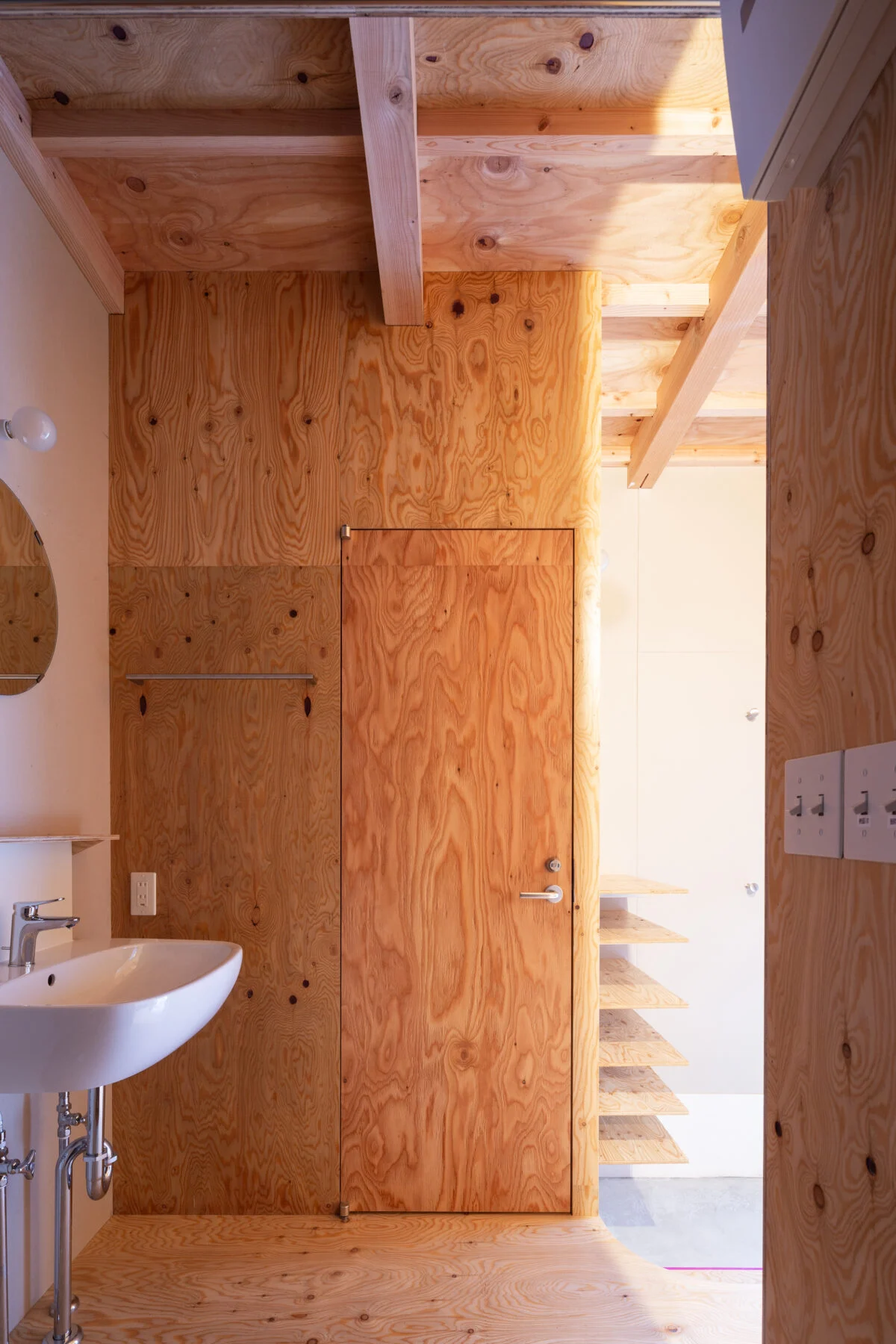 風呂からトイレ方向を臨む。トイレの開き戸が「駒込の住宅」唯一の建具だという。1階天井は表しに