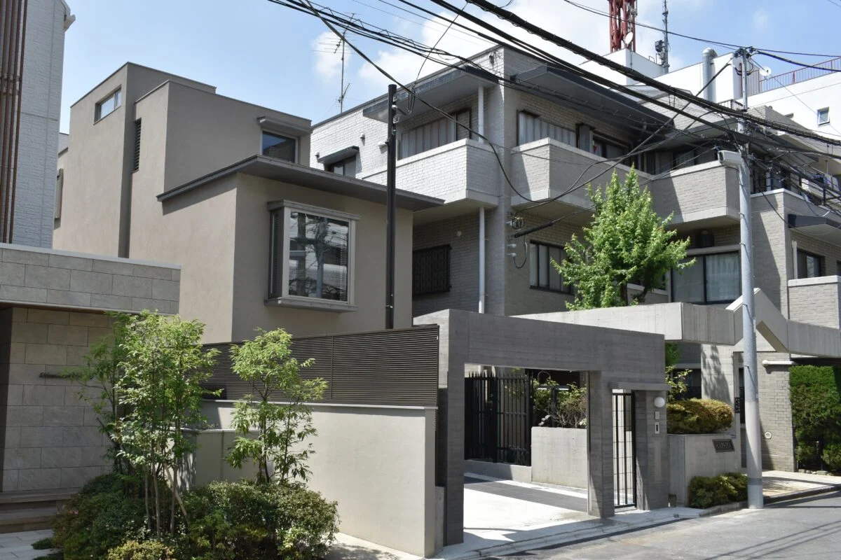 外観。建物正面の大きな窓は、リビングの出窓。杉板型枠によるコンクリート打ち放しの門扉やアルミフェンスで近隣との境界をしっかり仕切れるようにし、Fさんが気にしていた安全・安心を確保した