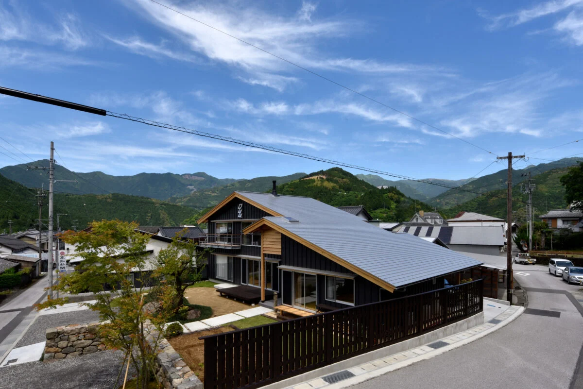 山並みに調和する大屋根が印象的。屋根はガルバリウムを横張りで、東側道路に面した屋根の軒高を1800mmほどに抑え、圧迫感を感じさせないように。屋根勾配は3寸5分、屋根に登っての煙突掃除もしやすい